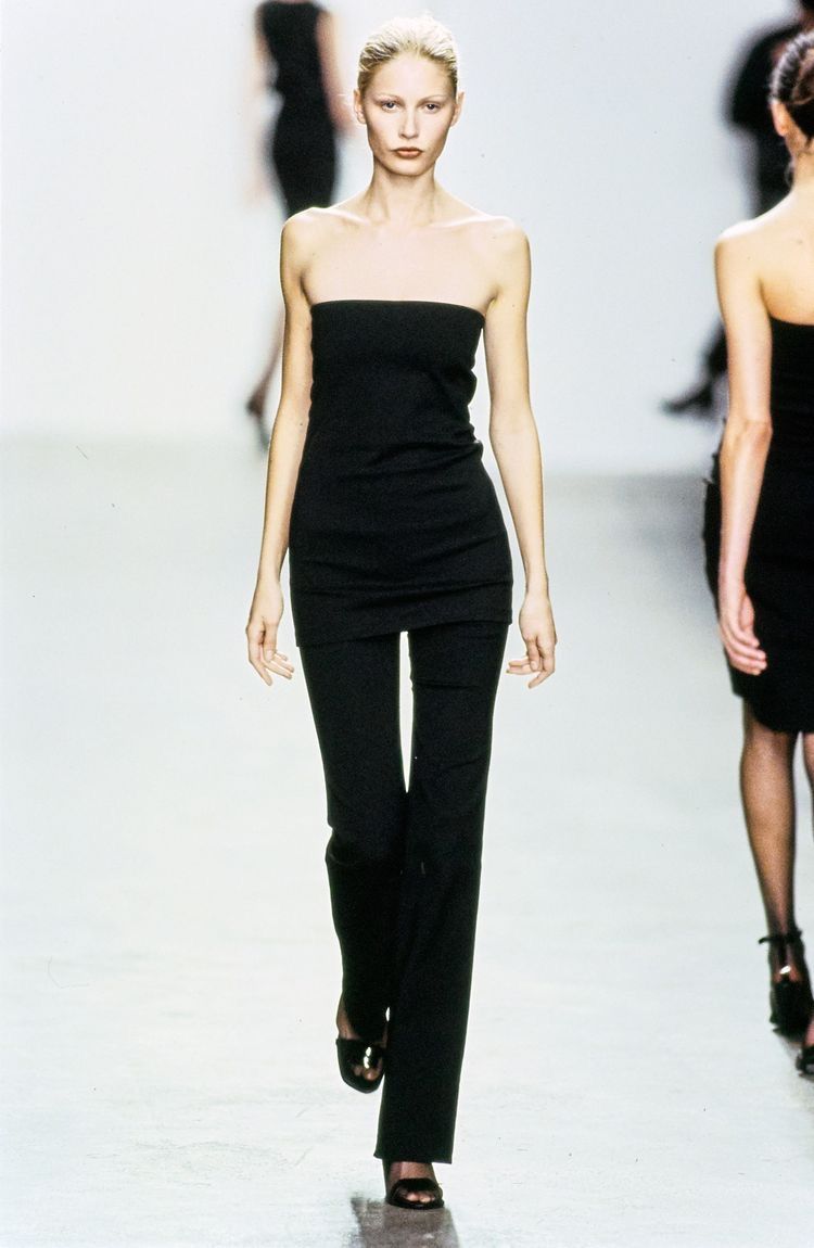 Runway model in a narrow black look with a long uninterrupted vertical silhouette