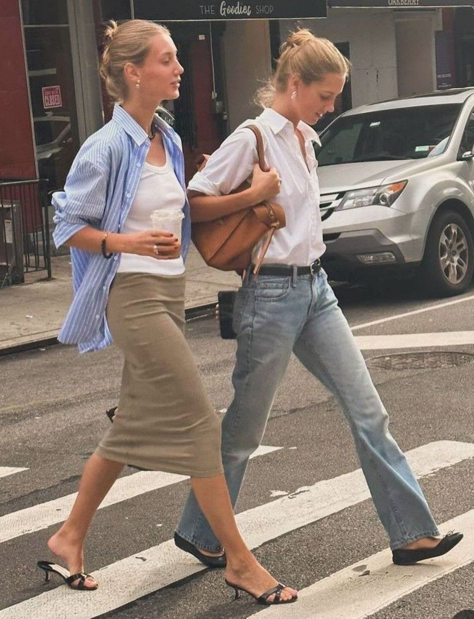 Two women in easy shirting and denim showing how the outer layer controls the silhouette